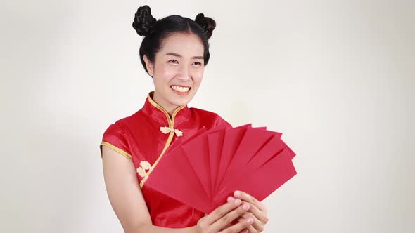 woman wear cheongsam and holding red envelope in concept of happy chinese new year