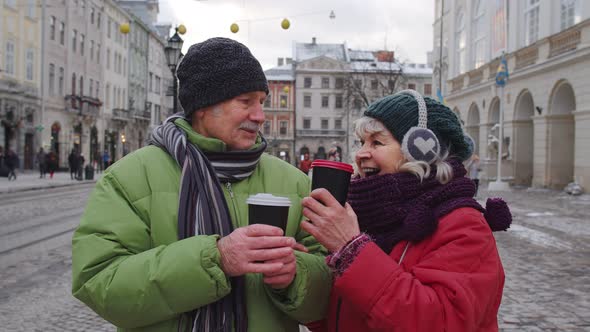 Senior Old Couple Tourists Grandmother Grandfather Traveling Drinking Hot Drink Tea in City Center