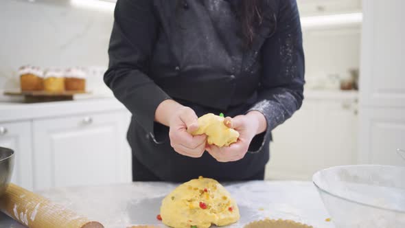 a Woman Cook Lays Out Dough in Paper Molds for Baking Easter Cakes