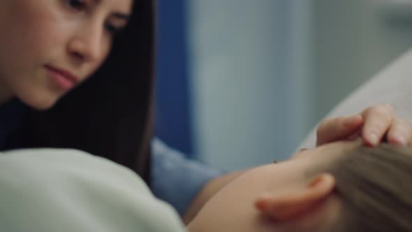 Worried Mother Comfort Child Lying in Bed Closeup