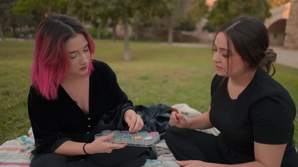 Two European Friends Talking About Cosmetics in a Park