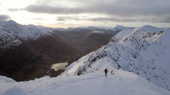 Mountain Climber at the Summit of a Mountain About to Traverse a Pass