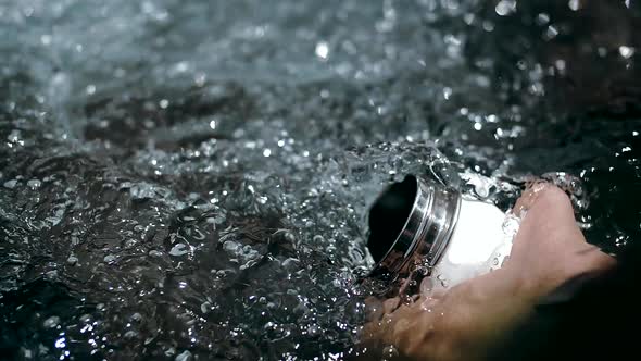 Man Picks Up Crystal Clear Water in a Sports Jar