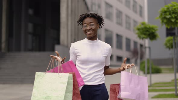 Young Attractive Joyful African Woman Smiling to Camera with Colorful Shopping Bags