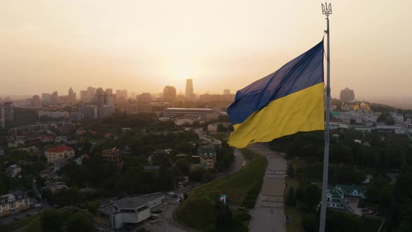 Aerial View of the Ukrainian Flag Waving in the Wind Against the City of Kyiv