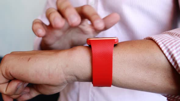 Mid-section of businessman using smartwatch