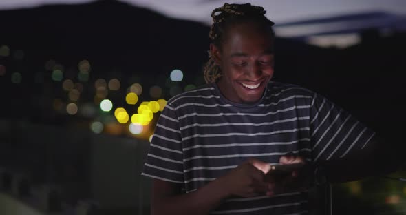 Afro American Man Using Smartphone in Night City Lights Backgorund