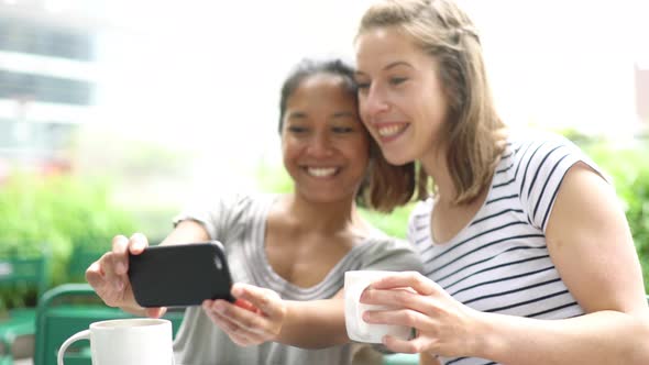 Women posing for a selfie in outdoor cafe