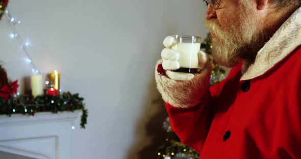 Santa claus relaxing on chair and having milk