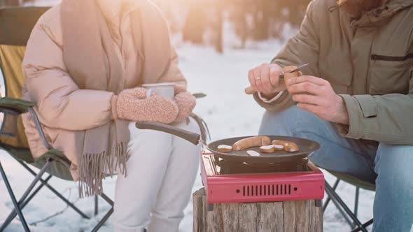 Couple Cooking Lunch at the Camp in the Woods on a Sunny Winter Day