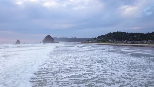 Aerial low drone flying at Cannon Beach in Oregon and Haystack Rock.