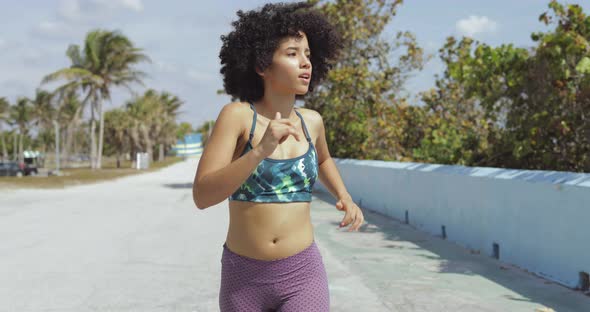 Black Fit Girl Jogging on Tropical Waterfront