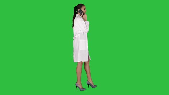 Female Dr Smiles While Talking on the Phone, Walking on a Green Screen, Chroma Key