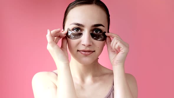 Head shot portrait close up smiling young woman with under eye moisturizing patches mask