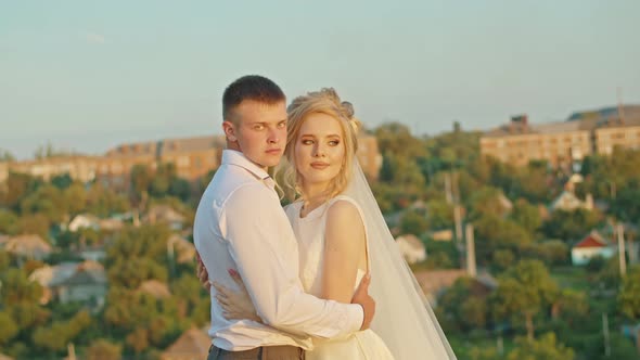 The Wedding Couple is Having Fun at Sunset on the Mountain Hills By the River