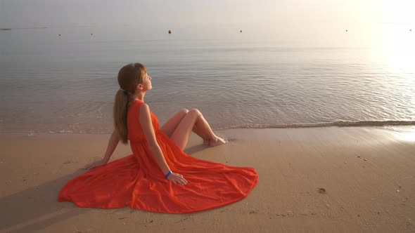 Lonely Young Woman Sitting on Ocean Sandy Beach By Seaside Enjoying Warm Tropical Evening