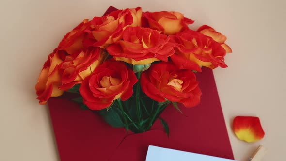 Bouquet of Red Roses Decorated in Paper Envelope on Beige Background