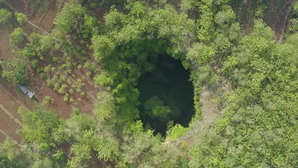 Top down drone shot view descending above the Jomblang Cave in Yogyakarta Indonesia