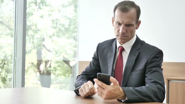 Shocked Astonished Businessman Using Smartphone