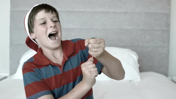 Happy boy using party popper in the bedroom in black and white