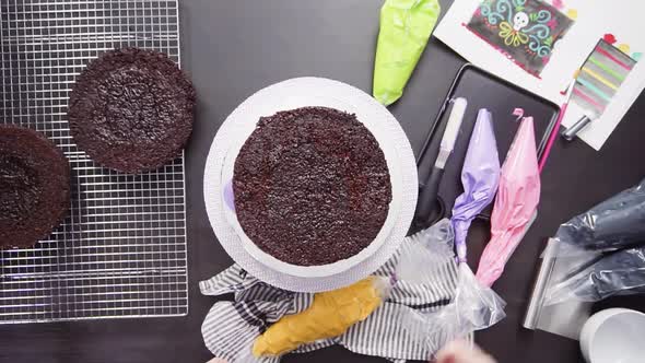 Step by step. Flat lay. Baker assembling a chocolate cake with bright colorful buttercream frosting 
