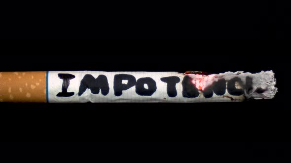 A Cigarette Smolders with the Word "Impotence". Cigarette on a Black Isolated Background