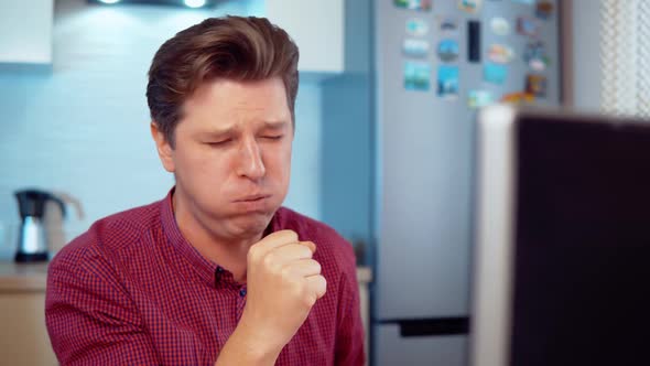 Man Coughs While Working at the Computer