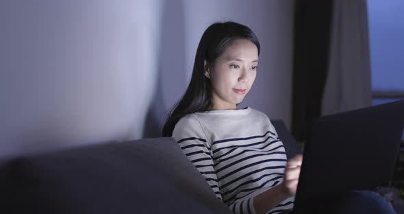 Woman using laptop computer at home in the evening