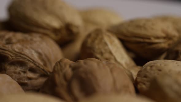 Cinematic, rotating shot of a variety of nuts on a white surface - NUTS MIXED 033