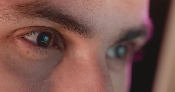 Closeup of a Young Man Eyes Look at the Monitor Work with a Computer Laptop