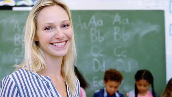 Portrait of happy teacher in classroom