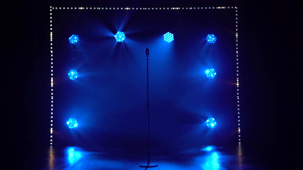 The Studio Has a Retro Style Microphone Set Against Dynamic Blue Neon Spotlights and Smoke. Vintage