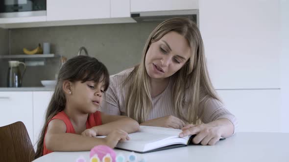 Mother Teaching Little Daughter To Read