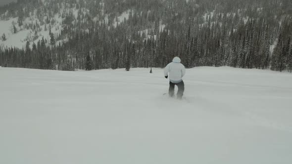 A Man Is Snowboarding Down a Mountain