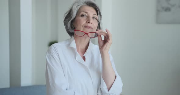 A Stunning Selfassured Elderly Lady Engineer Removes Her Spectacles and Looks at the Camera