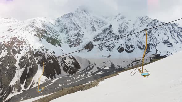 Ski Lifts on the Background of Snow Mountains