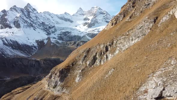 Close-to-flight on green, steep meadows to a snow-covered mountain range in the swiss alps, amazing