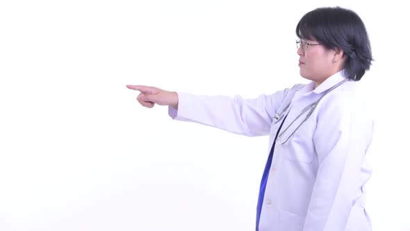 Profile View of Happy Overweight Asian Woman Doctor Pointing Finger