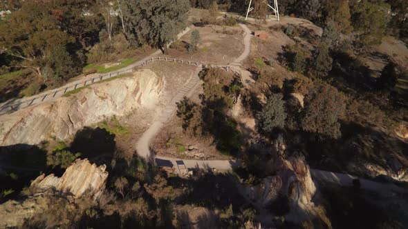 Sweeping drone shot of Victoria Hill Mining Reserve in Bendigo looking up to the poppet head on the