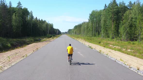 Aerial View From Drone on Man Riding on Asphalt Road