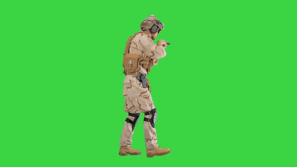 Armed Soldier in Camouflage Walking and Aiming with a Hand Gun on a Green Screen Chroma Key