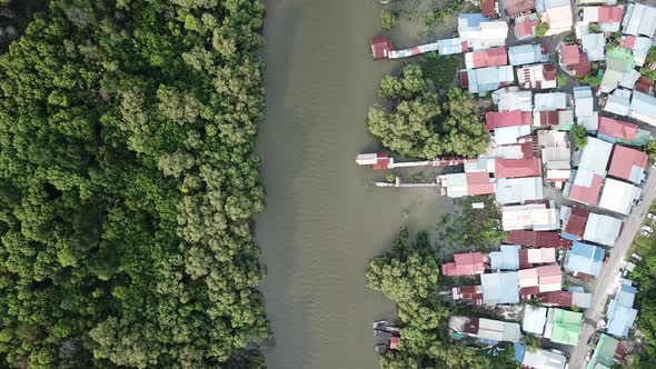 Aerial view river separate the mangrove forest and Malays housing village.