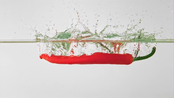 Super Slow Motion Chilli Pepper Falls Into the Water with Splashes