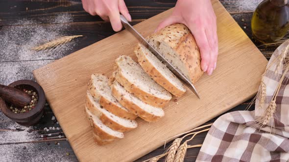 Woman Slicing Bread on Wooden Cutting Board