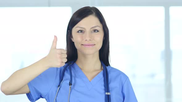 Portrait of Thumbs up by Doctor in Clinic
