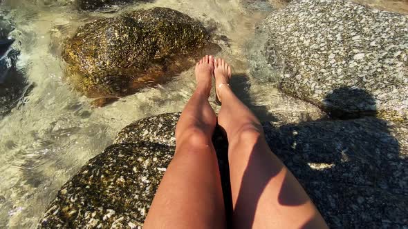 Women's Light Legs are on Stones Among Water