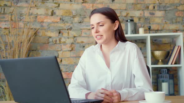 Confident Smiling Businesswoman Having a Video Conversation in Office