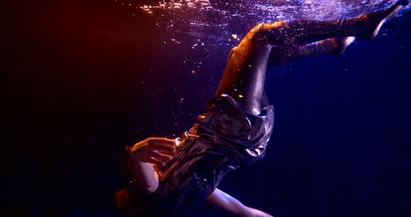 Close-up of a Dark-haired Middle-aged Woman Falling in a Studio Under Water and Floating on a Dark