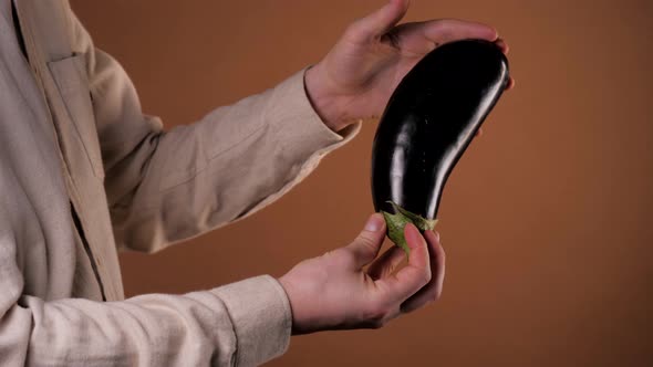 Man Holding an Eggplant Aubergine, Close-up