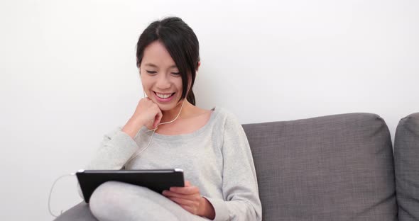 Woman watching on digital tablet computer at home 